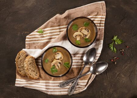 Delicious creamy mushroom soup with parsley and close-up on the dark background.の写真素材