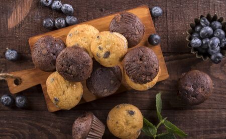 Blueberry and chocolate muffins on a wooden background. Top view.の写真素材