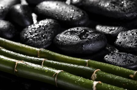 Bamboo with black zen stones on the black background. Spa concept