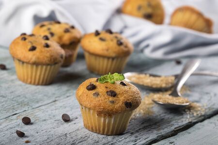 Chocolate vanilla fresh delicious muffins on a blue wooden backgroundの写真素材