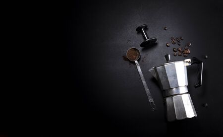 Coffee maker and utensils on a black background with copy space for text