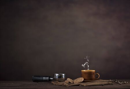 Coffee, cookies and utensils for coffee maker on dark brown background with copy space for textの写真素材