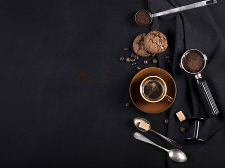 Coffee, cookies and utensils for coffee maker on black background with copy space for textの写真素材