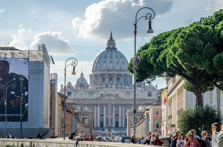 Foreign tourists strolling and being photographed in Rome, Italy on a bright sunny day in front of the dome of the main Catholic church of St. Peter the world at the Vaticanのeditorial素材