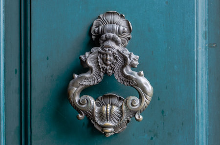Copper vintage retro doorknob with patterns of a woman's head and two naked mermaids bare-chested on the sidesのeditorial素材