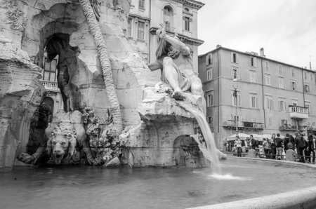 Roma, Italy - October 2015: Sculpture marble statue of a lion and a man on the fountain of the four rivers in Piazza Navona in Rome, capital of Italy, as well as tourists strolling on tripsのeditorial素材