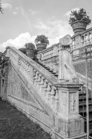 The steps and the road between the sculptures in the trees, bushes and grass in park at Villa Pamphili in Rome, capital of Italyのeditorial素材