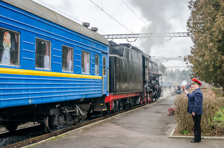 LVIV, UKRAINE - DECEMBER, 2015: Old vintage retro black locomotive with red star arrived at the station where he was photographed passengers and touristsのeditorial素材