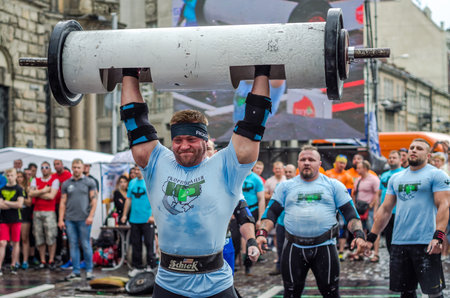 LVIV, UKRAINE - JUNE 2016: Strong athlete bodybuilder strongman inflated with a beautiful body to lift heavy barbell on the streetのeditorial素材