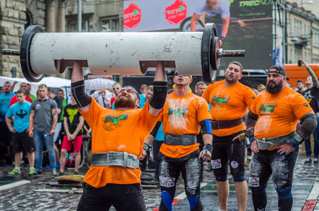 LVIV, UKRAINE - JUNE 2016: Strong athlete bodybuilder strongman inflated with a beautiful body to lift heavy barbell on the streetのeditorial素材