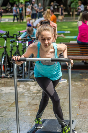 LVIV, UKRAINE - JUNE 2016: Young charming sports girl in the street shows different exercises on fitnessのeditorial素材