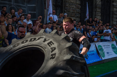 LVIV, UKRAINE - AUGUST 2017: A super strong athlete raises a huge Good Strongmen game at competitions in front of enthusiastic spectatorsのeditorial素材