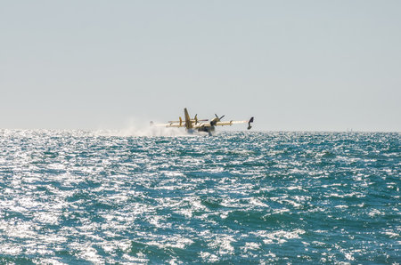 ROMA, ITALY - JULY 2017: A firefighting aircraft in an emergency situation, during a natural disaster, gathers water in the Tyrrhenian Sea to extinguish a fire and eliminate a catastrophe in Ostia, Italyのeditorial素材