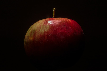 Red apple isolated on a black background in a low key