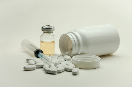 Pills, vitamins and syringe for injection with medications isolated on white background