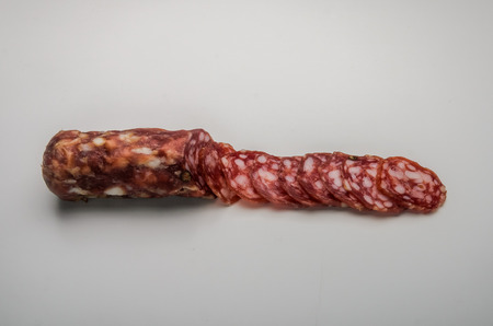 Sliced ??appetizing Italian sausage salami isolated on white backgroundの写真素材