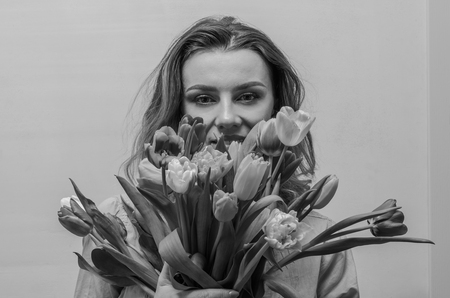 Young beautiful girl with a bouquet of flowers - multi-colored tulipsの写真素材
