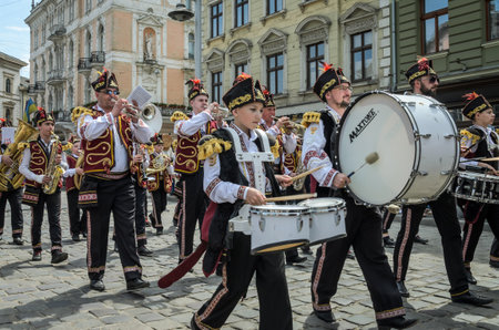 LVIV, UKRAINE - MAY 2018: A brass band with drums in carnival costumes is walking in the center of...