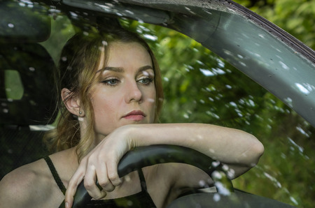 Young beautiful girl driving a carの写真素材