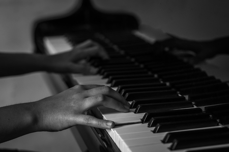 Hands on black and white piano keysの写真素材