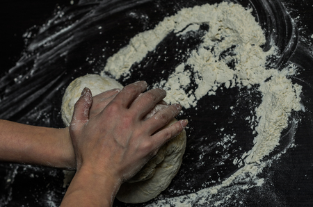 The cook kneads the dough with flourの写真素材