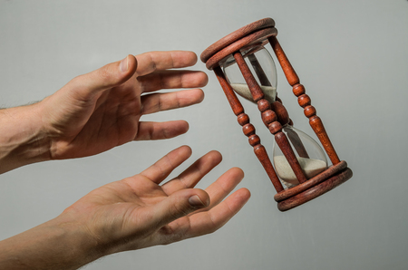 Human hands want to catch the time in the hourglassの写真素材