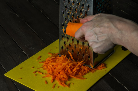 The hands of the cook grated carrotsの写真素材