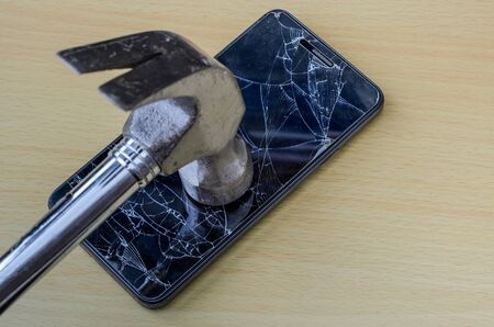 A hammer breaks the screen of a smartphoneの写真素材
