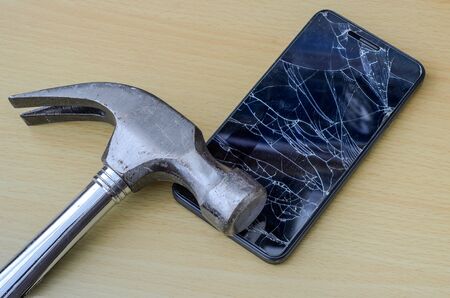 A hammer breaks the screen of a smartphoneの写真素材