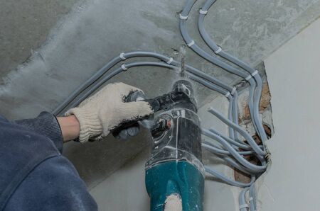 Worker drills a concrete wall with a hammer drillの写真素材