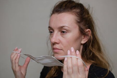 Young woman puts on a medical mask