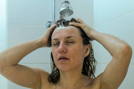 Young charming girl washes in the shower