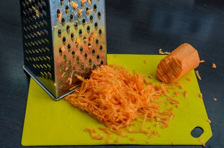Grated carrots and steel graterの写真素材
