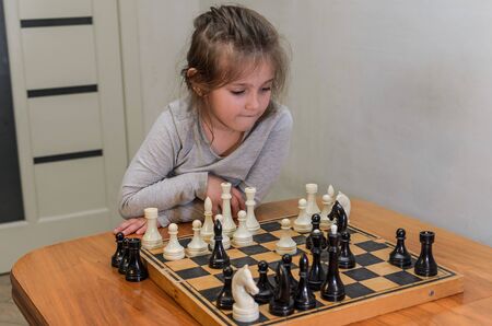 Little charming girl child playing chess