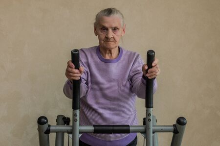 An elderly woman is engaged in a sports simulator at home