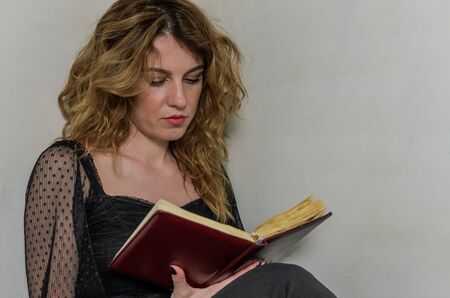 Young woman sits with a book