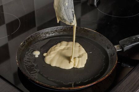 Pancakes are fried in a pan on an induction stove