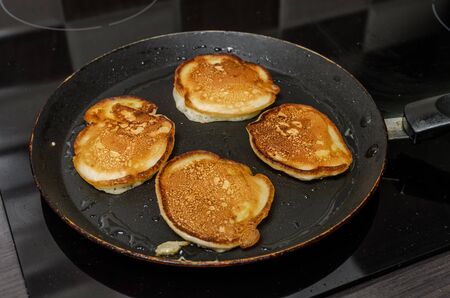Pancakes are fried in a pan on an induction stove