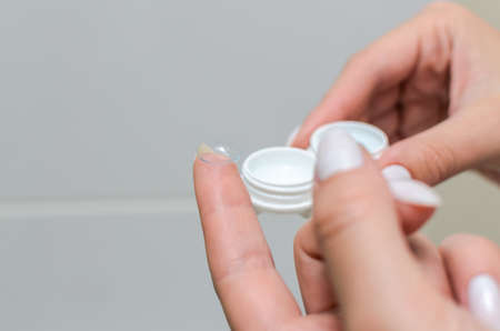 Removes contact lenses for vision correction and places them in a contact lens containerの写真素材