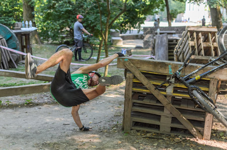 LVIV, UKRAINE - AUGUST 2020: An athlete falls off a bicycle while performing extreme stunts on a bike trialのeditorial素材