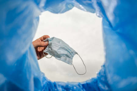 Man throws a used medical mask into the trash canの写真素材