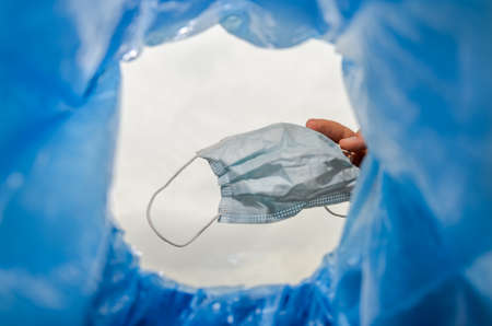 Man throws a used medical mask into the trash canの写真素材