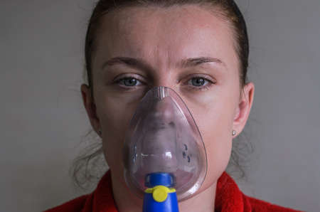 Woman doing medical procedure - respiratory inhalation in maskの写真素材