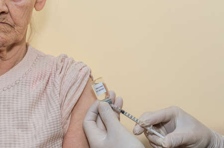 An elderly woman is being vaccinated against the virusの写真素材