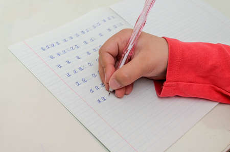 Little girl child doing homework, learning to write letters