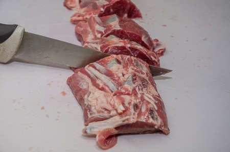Butcher cuts lamb fillet with a knife on a cutting boardの写真素材