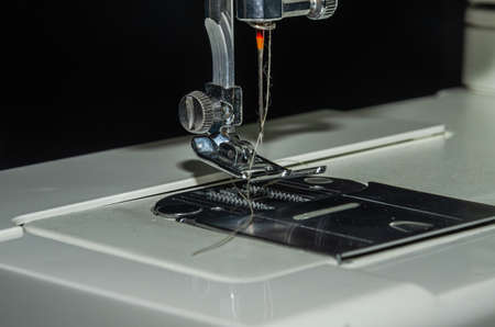 Tailor sews fabric for clothing on a sewing machine in a tailor shop