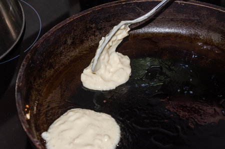 The cook is frying pancakes in a frying pan