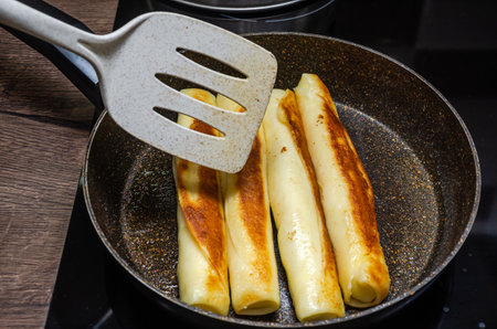 The cook fries pancakes for breakfast in a frying pan