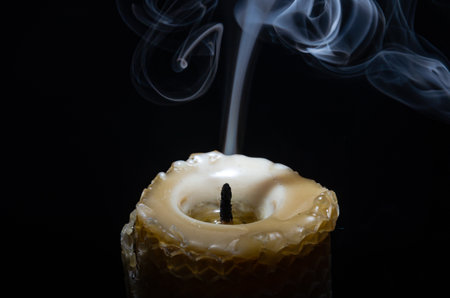 Fuming extinguished candle isolated on black backgroundの写真素材